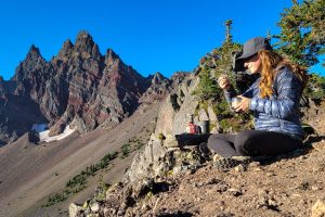 woman eating a backpacking meal in the mountains