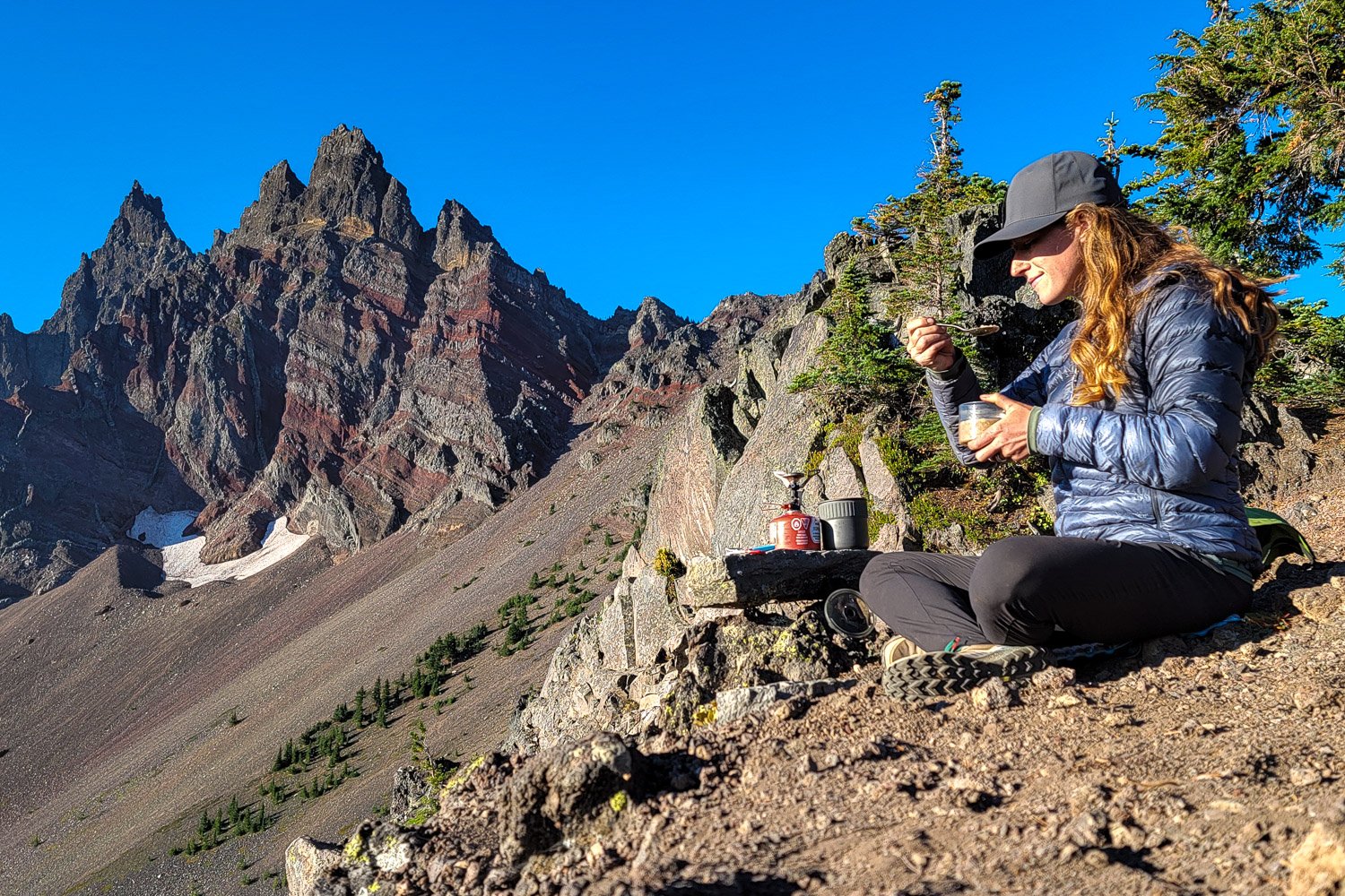 woman eating a backpacking meal in the mountains