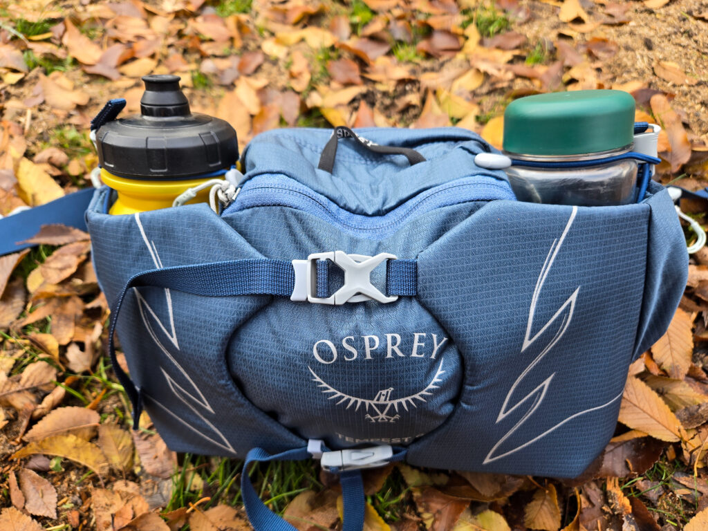 the osprey waist pack loaded with water bottles on the ground