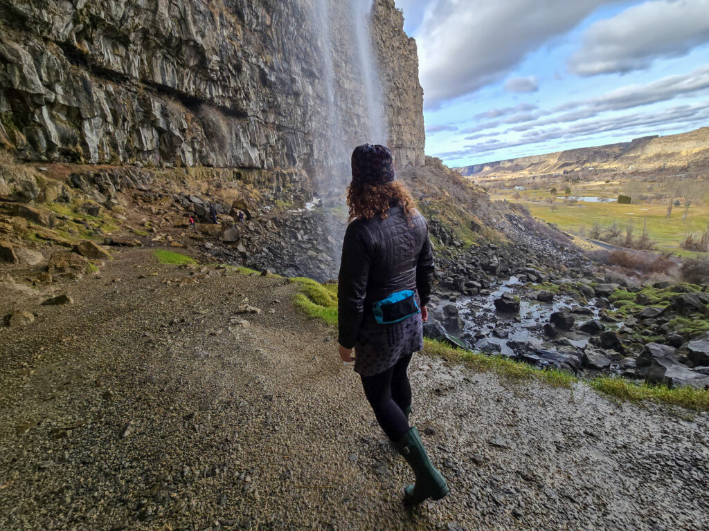 a woman wearing a liteaf featherweight fanny pack next to a waterfall