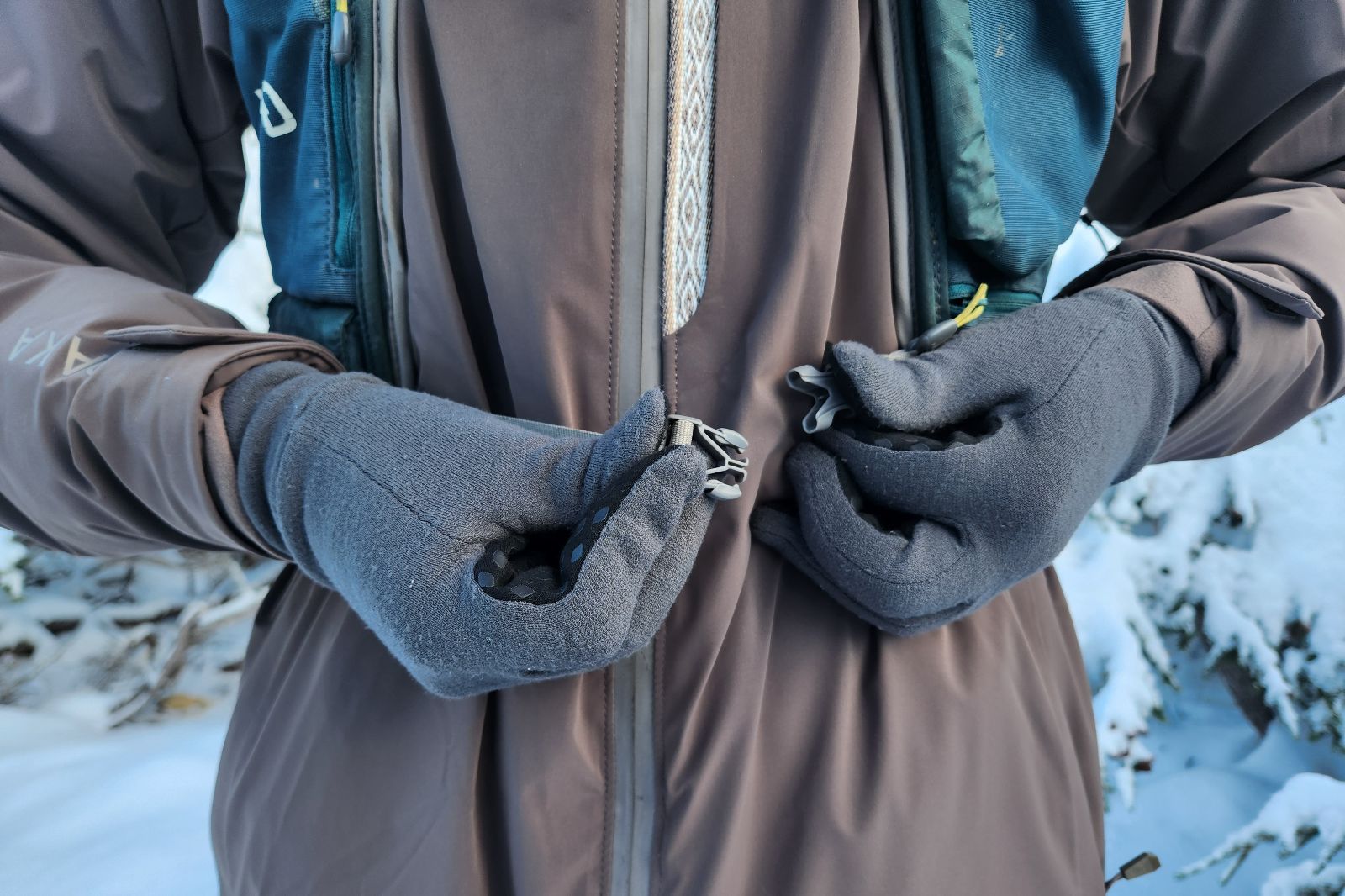 A pair of gloved hands buckling a strap.
