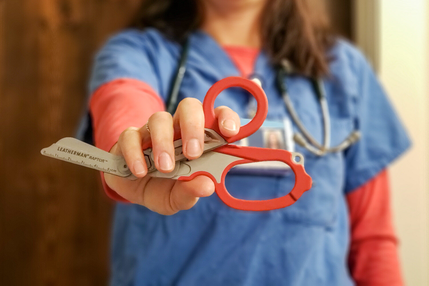 A-nurse-in-scrubs-holding-the-Leatherman-Raptor-Multitool