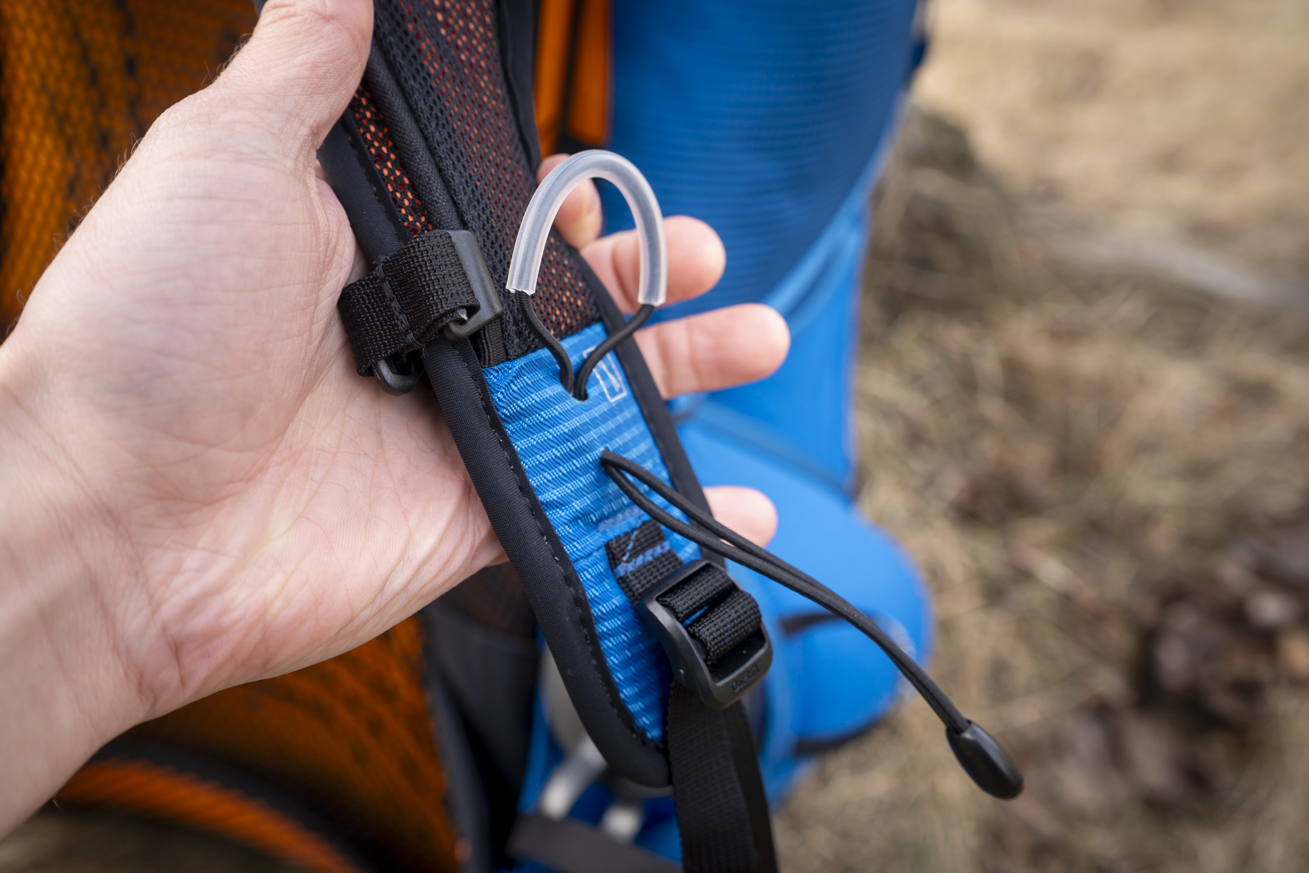 a hand holds a backpack strap
