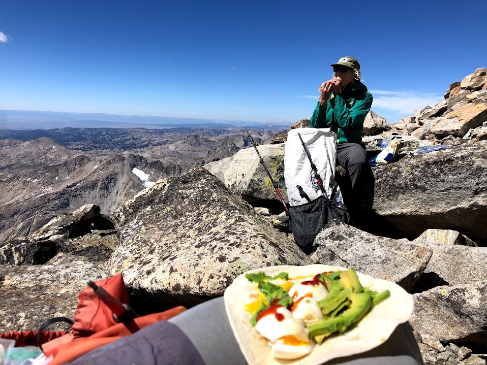 hikers eating lunch with food on a lap