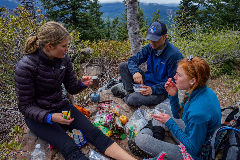 group of hikers with their food and snacks on the ground