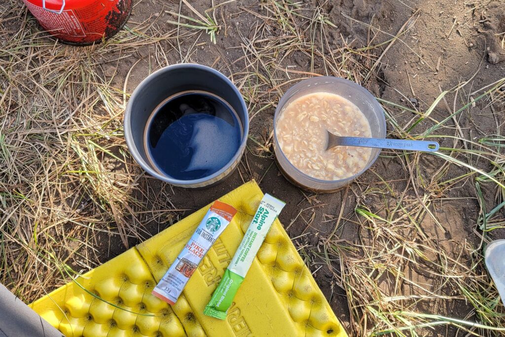 coffee and oatmeal in camp cups on the ground