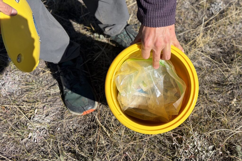 a top down view of a food bag inside of a yellow bear canister