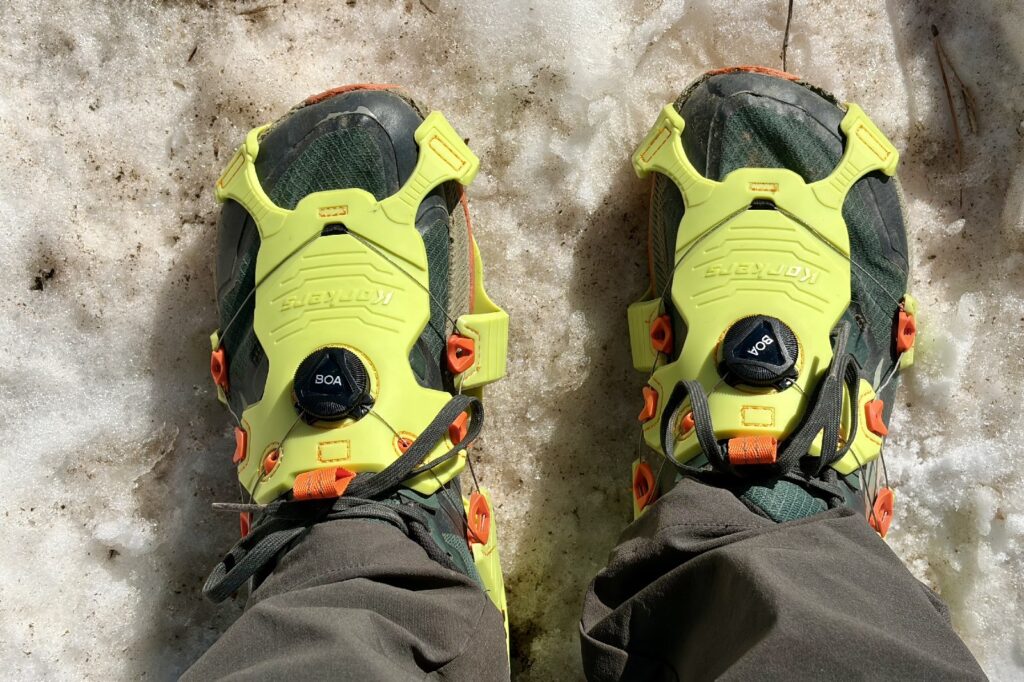 a POV view of a hikers feet with trail runners and ice cleats