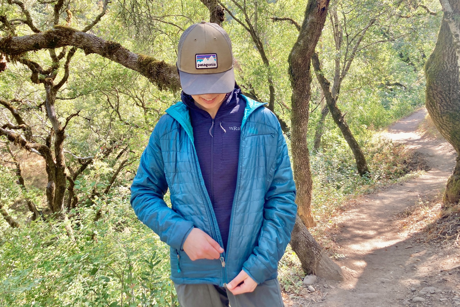 A woman zips up a puffy jacket over her fleece.
