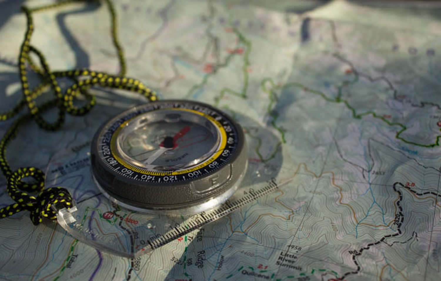 close up of compass resting on a map
