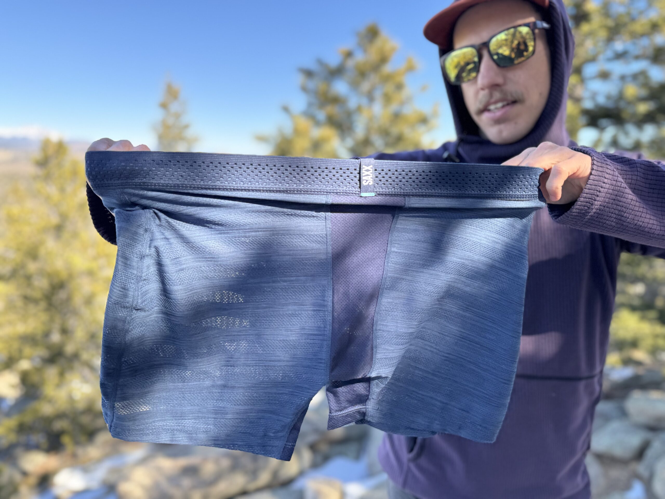 A hiker stretches the waistband of a pair of SAXX underwear.