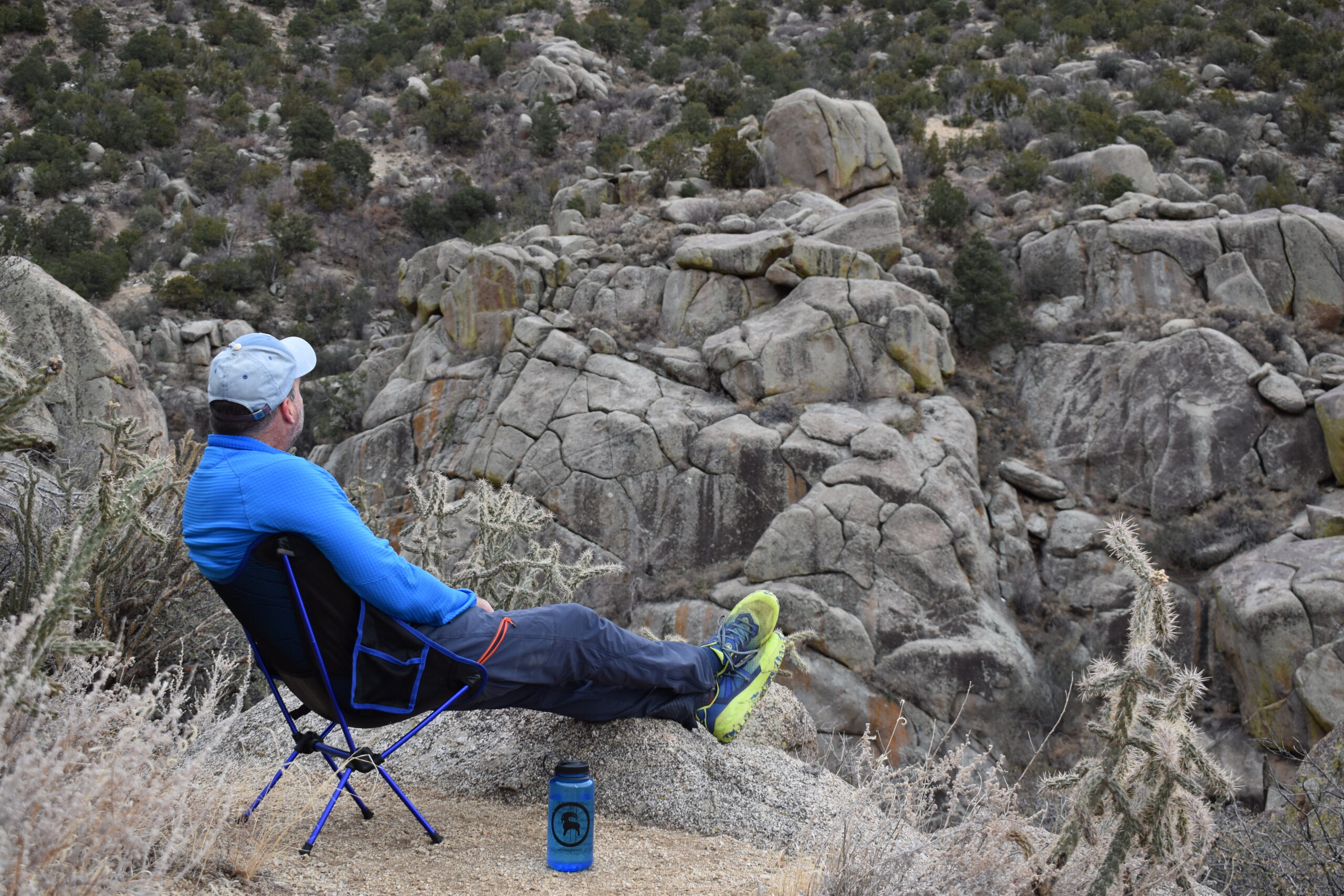a backpacker stares across a canyon while sitting comfortably in the Moon Lence Portable chair