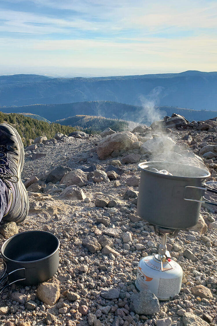 backpacking stove and pot cooking in the mountains